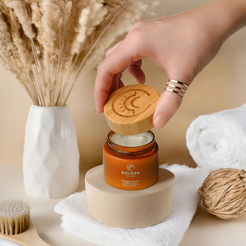 Hand holding a branded Golden Tallow jar